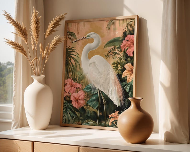 Great egret art print featuring a graceful white heron standing among lush tropical leaves and colourful flowers. Detailed wildlife artwork with elegant composition, perfect for bird lovers and nature enthusiasts. Botanical tropical painting that adds sophistication and serenity to any living room, bedroom, office, or nursery, creating a calming atmosphere. Wildlife inspired wall decor that highlights the beauty of the egret and the harmony of nature through vibrant colours and refined design.