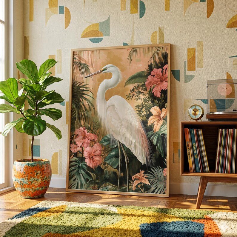 a large framed painting of a white heron surrounded by tropical foliage, including pink flowers, on a wall in a room with a colorful rug and a potted plant.