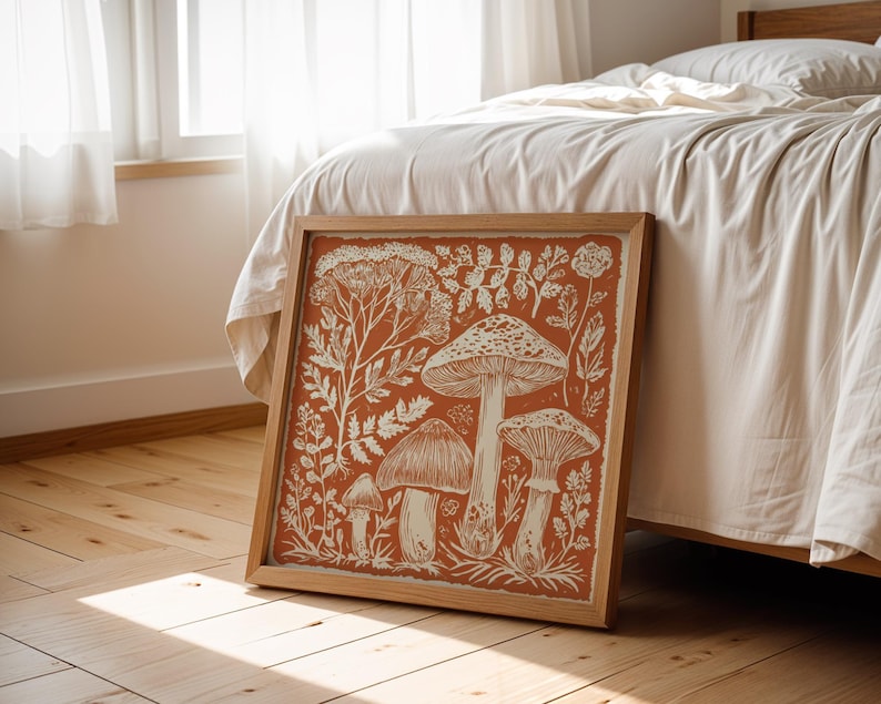 Autumn mushroom art print featuring a tall central mushroom surrounded by smaller mushrooms and woodland botanicals in warm earthy tones. Detailed fall botanical illustration that captures the beauty of forest landscapes, ideal for rustic kitchens, autumn cottagecore interiors, woodland décor or seasonal gallery walls. Perfect mushroom wall art for adding warm autumn charm and woodland character to any space.