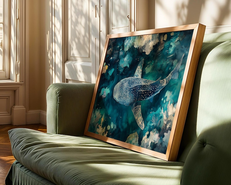 a framed painting of a whale shark swimming in the ocean, displayed on a green couch in a room with sunlight streaming in through a window.