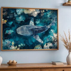 a large framed painting of a whale shark swimming in the ocean, hanging on a wall above a wooden dresser.