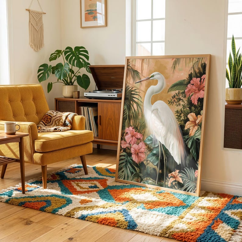 a living room with a large painting of a white crane standing on a colorful rug, a yellow armchair, a wooden side table with a record player and records, and a large window with a plant.