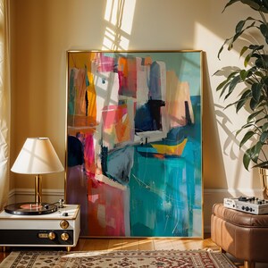 a large abstract painting displayed in a room with a record player, a lamp, and a potted plant.