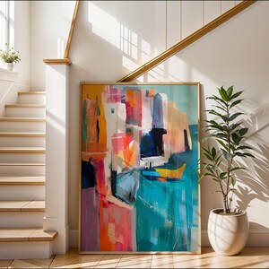a large, colorful abstract painting displayed on a wall, with a staircase and a potted plant in the background.