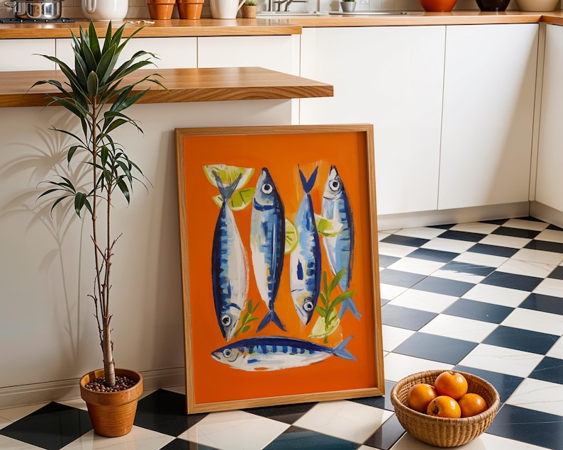a kitchen scene with a framed artwork of fish on the floor, a potted plant, a basket of oranges, and a checkered tile floor.