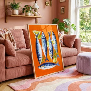 a vibrant orange and blue fish painting displayed on a pink couch in a cozy living room setting.