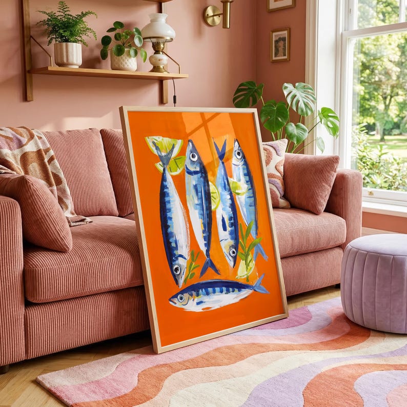 a vibrant orange and blue fish painting displayed on a pink couch in a cozy living room setting.