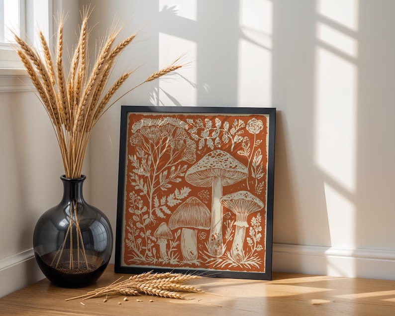 Autumn mushroom art print featuring a tall central mushroom surrounded by smaller mushrooms and woodland botanicals in warm earthy tones. Detailed fall botanical illustration that captures the beauty of forest landscapes, ideal for rustic kitchens, autumn cottagecore interiors, woodland décor or seasonal gallery walls. Perfect mushroom wall art for adding warm autumn charm and woodland character to any space.