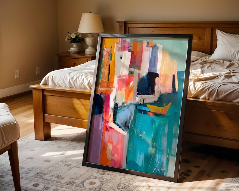 a large, colorful abstract painting displayed on a wooden floor in a bedroom.