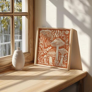 Autumn mushroom art print featuring a tall central mushroom surrounded by smaller mushrooms and woodland botanicals in warm earthy tones. Detailed fall botanical illustration that captures the beauty of forest landscapes, ideal for rustic kitchens, autumn cottagecore interiors, woodland décor or seasonal gallery walls. Perfect mushroom wall art for adding warm autumn charm and woodland character to any space.