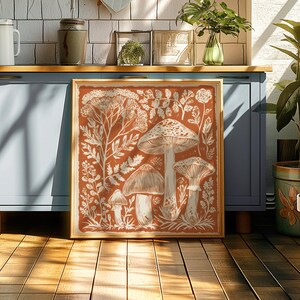 a framed artwork depicting a forest scene with mushrooms, surrounded by various plants and flowers.
