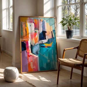 a large abstract painting displayed in a room with a wooden chair and a potted plant.
