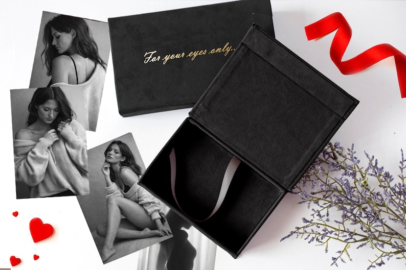 May include: Black gift box with the text "For your eyes only" in gold lettering. The box is open, revealing a satin ribbon. The image also includes black and white photographs of a woman, red heart decorations, and a red ribbon.