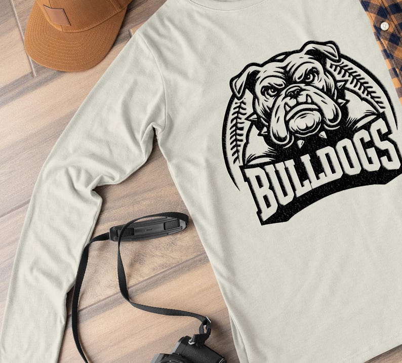 May include: A white long-sleeve shirt with a black and white graphic of a bulldog's head with the word "BULLDOGS" underneath.