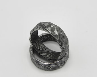 May include: Two silver metal rings with a patterned design. The rings are stacked on top of each other.