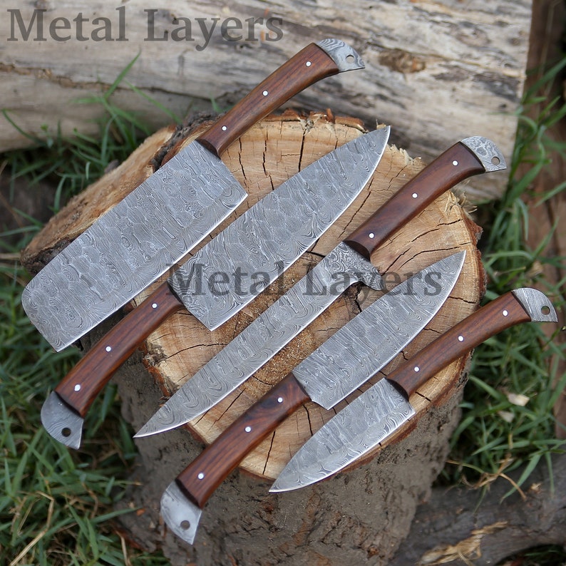 May include: Set of five kitchen knives with wooden handles and Damascus steel blades. The knives are arranged on a wooden stump.