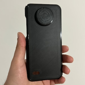 May include: A black phone case with a circular cutout on the back for a camera lens