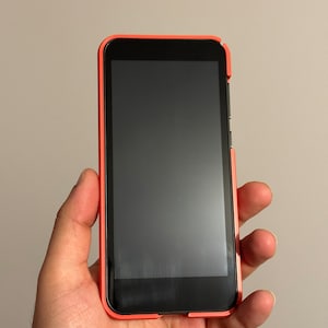 May include: A red smartphone with a black screen
