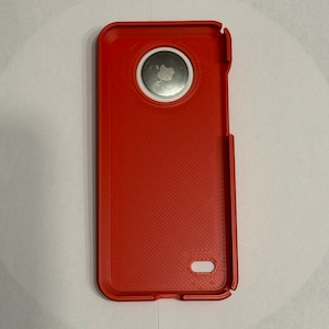 May include: A red phone case with a white circle around the camera lens. The case has a textured surface.
