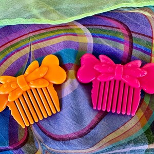 May include: A white ceramic mug with a black handle and the text "But First, Coffee" in a bold, black font. The mug is set against a blurred background, suggesting a cozy setting.