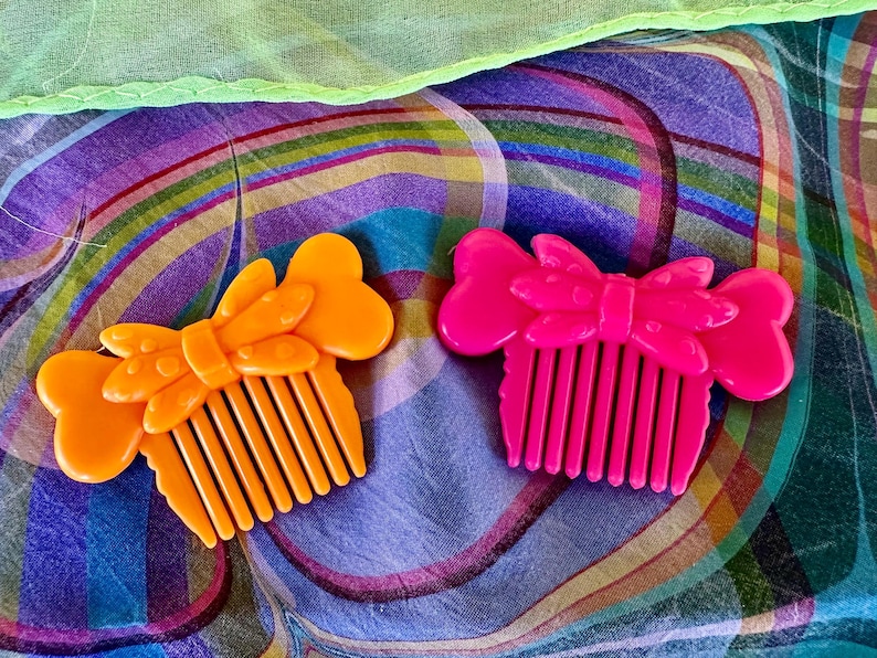 May include: A white ceramic mug with a black handle and the text "But First, Coffee" in a bold, black font. The mug is set against a blurred background, suggesting a cozy setting.
