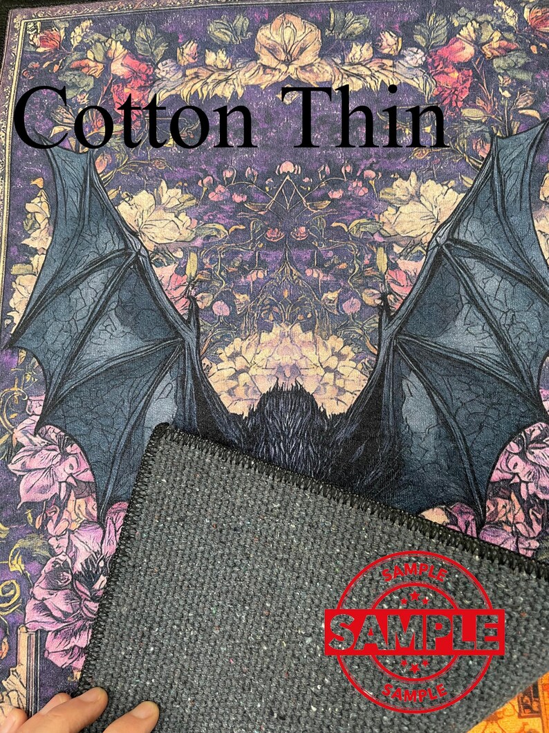 Puede incluir: Un murci&eacute;lago negro con las alas extendidas sobre un fondo floral morado. El texto "Cotton Thin" est&aacute; en la parte superior de la imagen. La imagen es una muestra de una alfombra.