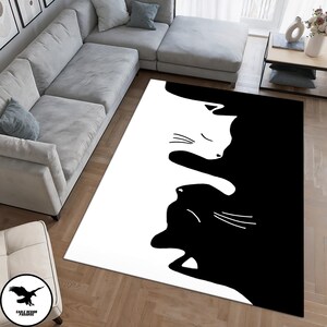 May include: Black and white area rug with a design of two cats facing each other. The cats are outlined in black and white, creating a yin yang effect.