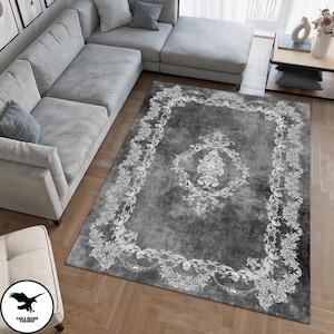 May include: A gray and white area rug with a floral pattern. The rug has a distressed look and a white border.