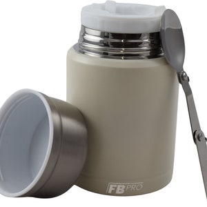 May include: A beige insulated food container with a white lid and a stainless steel interior. A stainless steel folding spoon rests beside the container. The container's lid is open, and the container's lid is next to the container. The container has the text "FB PRO" on the side.