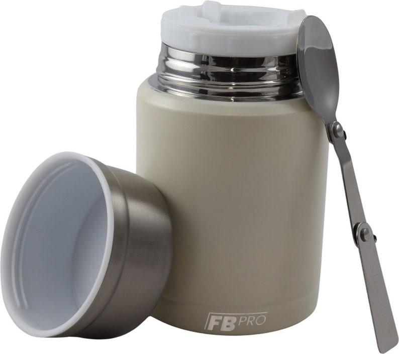 May include: A beige insulated food container with a white lid and a stainless steel interior. A stainless steel folding spoon rests beside the container. The container's lid is open, and the container's lid is next to the container. The container has the text "FB PRO" on the side.