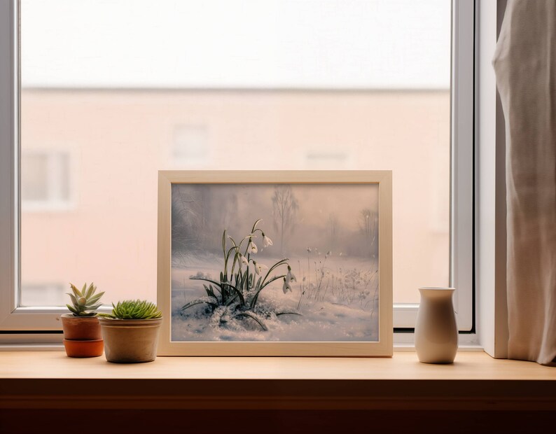 May include: A framed painting of a snowy landscape with white flowers in the foreground. The painting is on a windowsill with two potted succulents.