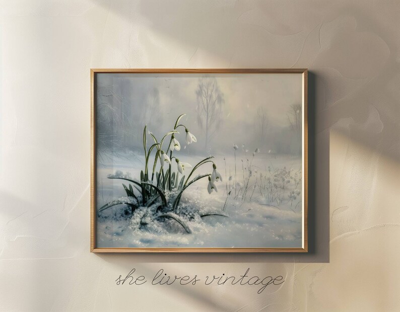 May include: A framed painting of a snowy forest scene with a cluster of white snowdrop flowers in the foreground. The flowers are in focus, while the background is blurred and hazy.