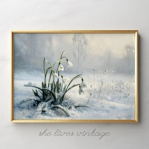 May include: A framed painting of a snowy forest scene with white snowdrops blooming in the foreground. The painting has a soft, dreamy feel and features a light blue and white color palette.