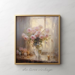 May include: A framed floral painting featuring a bouquet of pink roses in a clear glass vase. The artwork has a soft, romantic aesthetic, with a gold frame and the text "she lives vintage" at the bottom.
