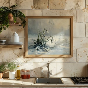 May include: A framed painting of a snowy landscape with white snowdrops in bloom. The painting is hanging on a wall with beige tiles.