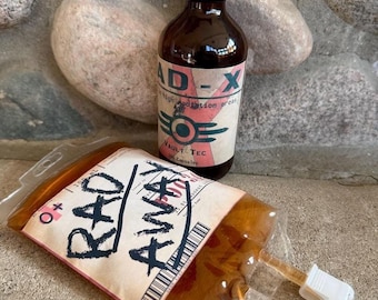 May include: A brown glass bottle labeled "RAD-X" with a black cap, and a clear plastic bag labeled "RAD AWAY". The bottle has a retro design with the text "high radiation areas" and a Vault-Tec logo. The bag contains a brown liquid.