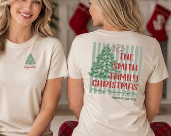 May include: A cream-colored short-sleeve t-shirt featuring a small green Christmas tree and the name Sophia in red on the front. The back displays a green striped background, a large Christmas tree, and text reading The Smith Family Christmas.