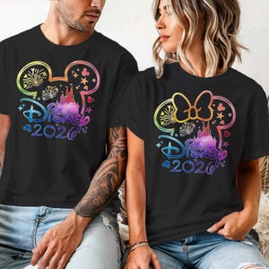 May include: Black t-shirts with a colorful Disney design. The design includes Mickey Mouse ears, a castle, fireworks, and the text "Disney 2020". The design is in rainbow colors.