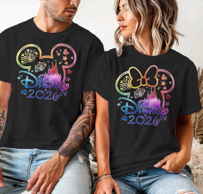 May include: Black t-shirts with a colorful Disney design. The design includes Mickey Mouse ears, a castle, fireworks, and the text "Disney 2020". The design is in rainbow colors.