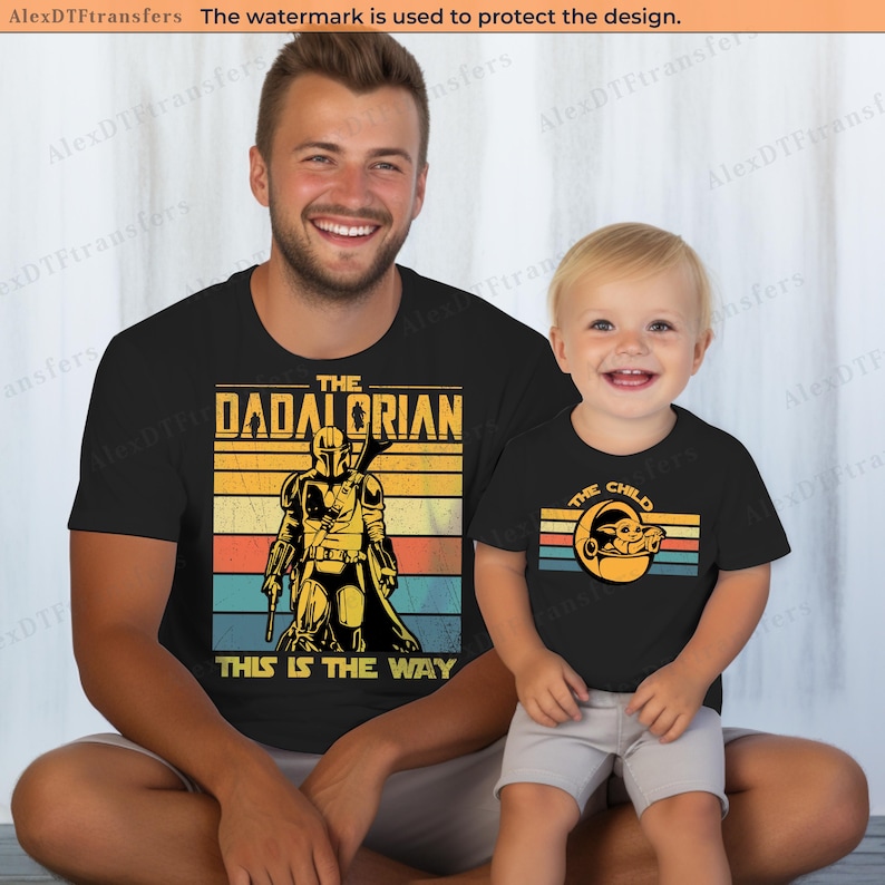 K&ouml;nnte beinhalten: Schwarze T-Shirts mit passenden Designs. Ein Shirt sagt "THE DADALORIAN THIS IS THE WAY" mit einer Mandalorianer-Grafik. Das andere Shirt sagt "THE CHILD" mit einer Grogu-Grafik. Beide Shirts haben einen Retro-Stil.