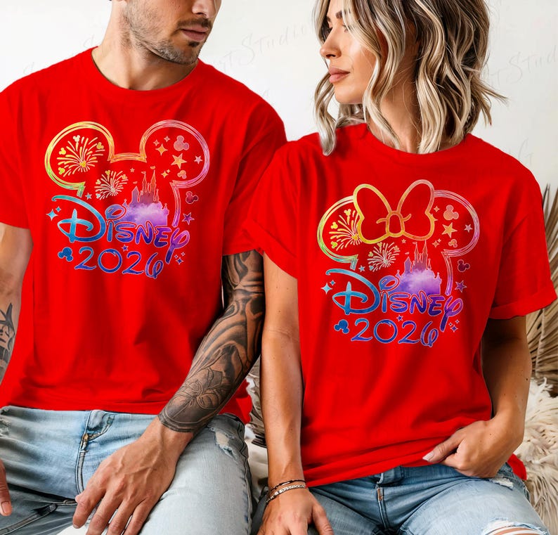 May include: Red t-shirts featuring a colorful Disney design with the text "Disney 2020". The design includes a castle, fireworks, and a Mickey Mouse ear silhouette. The shirts are short-sleeved.