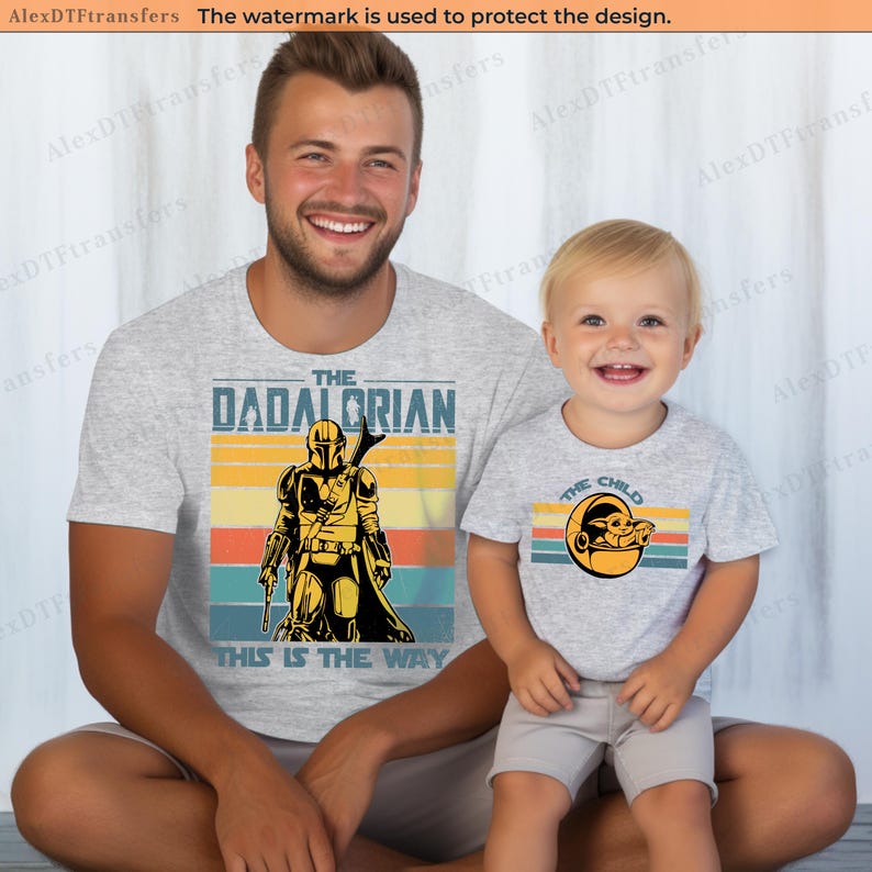 K&ouml;nnte beinhalten: Zwei passende hellgraue T-Shirts mit Star Wars-Motiven. Eines zeigt "The Dadalorian" mit einer Mandalorianer-Figur, das andere "The Child" mit Grogu. Beide Shirts haben ein Retro-Sonnenuntergangsdesign.