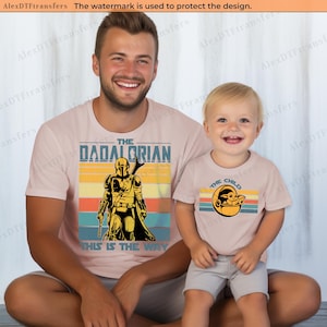 K&ouml;nnte beinhalten: Passende hellrosa T-Shirts mit grafischen Designs. Ein Shirt sagt "The Dadalorian" mit einer Mandalorianer-Illustration und "This is the Way". Das andere Shirt sagt "The Child" mit einer Grogu-Grafik.