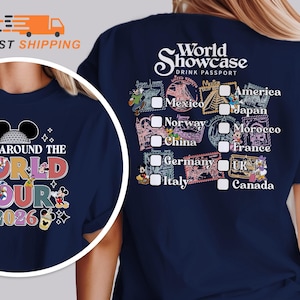 May include: A navy blue t-shirt featuring a graphic design on the back and a circular inset on the front. The back displays the text World Showcase Drink Passport with a checklist of countries including America, Japan, Mexico, Norway, Morocco, China, France, Germany, UK, and Canada. The front inset shows the text Drink Around The World Tour 2026 with cartoon characters and beverage illustrations.