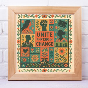 May include: A framed art print with a wooden frame. The artwork features a colorful, geometric design with the text "UNITE FOR CHANGE." The design includes silhouettes, flowers, and a raised fist. The print is displayed on a white brick wall.