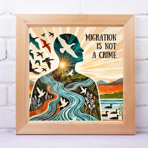 Könnte beinhalten: Ein gerahmter Kunstdruck mit dem Text "MIGRATION IS NOT A CRIME". Das Kunstwerk zeigt die Silhouette einer Person mit einem Fluss, der durch sie fließt, Vögeln und einem Sonnenuntergang. Der Rahmen ist aus hellem Holz.