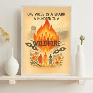 May include: Framed art print with the text "ONE VOICE IS A SPARK A HUNDRED IS A WILDFIRE." The artwork features a fiery illustration with silhouettes of people, chains, and barbed wire, set against a warm, orange background.