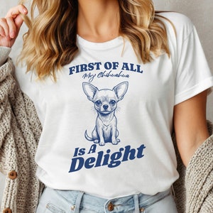 May include: White t-shirt with a blue graphic of a chihuahua and the text "First of all, my chihuahua is a delight."