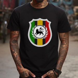 May include: Black t-shirt with a graphic of a lion in a shield with red, yellow, and green stripes. The lion is black and the shield is white.