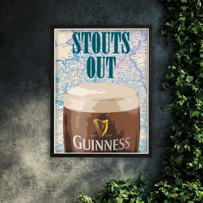 Puede incluir: Impresi&oacute;n enmarcada que muestra una pinta de Guinness stout con una cabeza cremosa. Las palabras "STOUTS OUT" est&aacute;n en verde azulado sobre el vaso, sobre un fondo de mapa. El logotipo de Guinness se muestra de forma destacada.